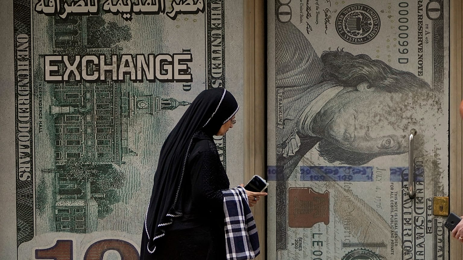 إمرأة مصرية أمام مكتب صرافة في القاهرة
