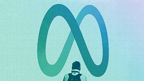 A person stands in front of a Meta sign outside of the company's headquarters in Menlo Park, March 2024