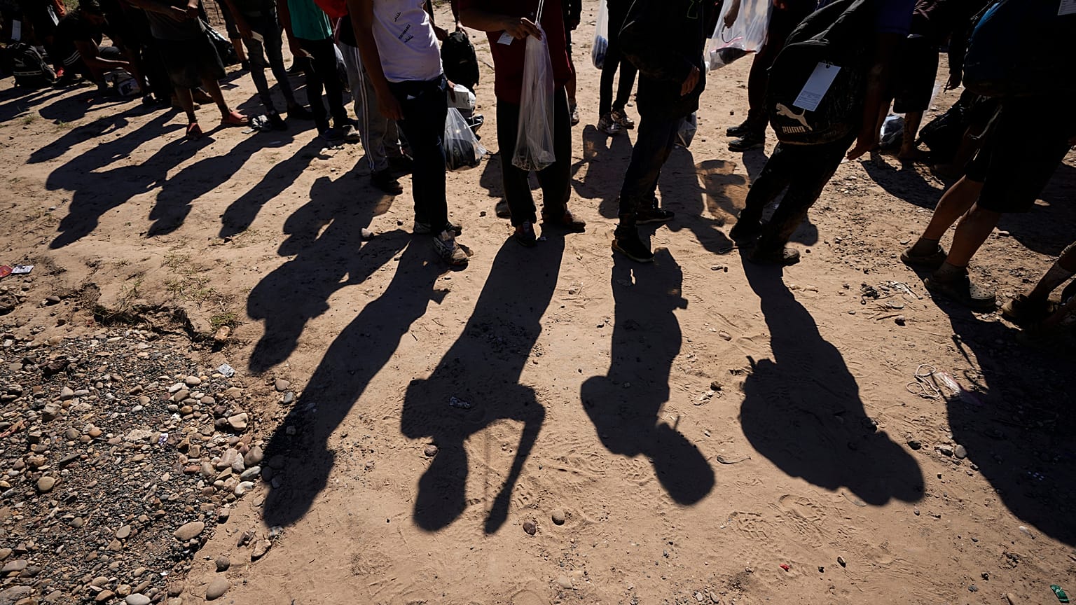 Des migrants attendent d'être contrôlés par les autorités américaines à la frontière entre États-Unis et le Mexique, le 19 octobre 2023, à Eagle Pass, au Texas.