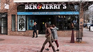 Pedestrians walk on Church St., past the Ben & Jerry's shop, in Burlington, Vt., Wednesday, March 11, 2020