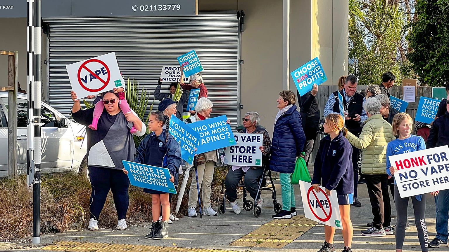 People protest outside an Auckland school near where a vape shop was set to open, Aug 1, 2023.