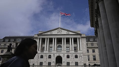 A woman walks in front of the Bank of England, at the financial district in London, on March 23, 2023. 