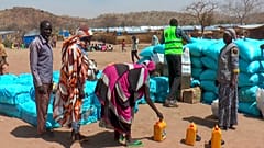لاجئون سودانيون نزحوا بسبب النزاع في السودان يتجمعون لتسلّم مواد غذائية أساسية من وكالات إغاثة داخل مخيم متشي في شرق تشاد، في 5 مارس 2024.