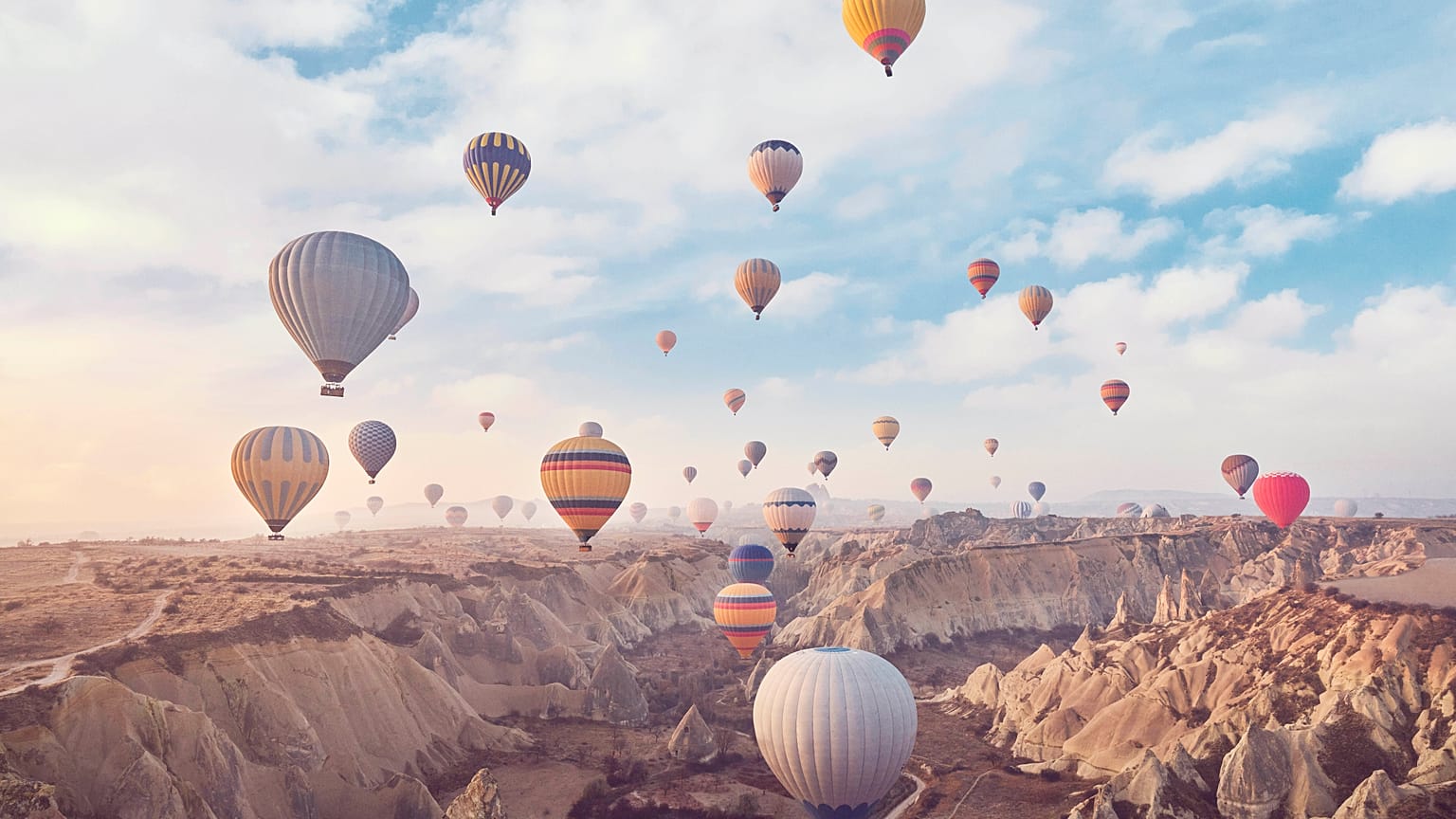 Unos globos aerostáticos con turistas se elevan sobre las Chimeneas de Hadas de Capadocia, ubicadas en el centro de Turquía.