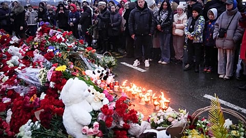 People gather to lay flowers and light candles next to the Crocus City Hall, on the western edge of Moscow, Russia, Saturday, 23 March, 2024. 