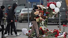 Des personnes déposent des fleurs et des jouets devant le Crocus City Hall, à l'ouest de Moscou, en Russie, le samedi 23 mars 2024.