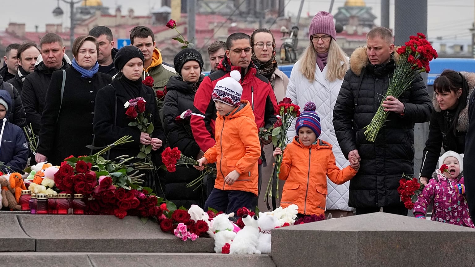 Persone depongono fiori in un monumento spontaneo in memoria delle vittime dell'attentato di Mosca a San Pietroburgo, Russia, domenica 24 marzo 2024. 