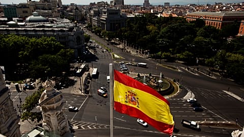 A Spanish flag waves above the Cibeles square close to Spain's Bank, left, seen from a balcony of Madrid's city hall, in Madrid, Spain.