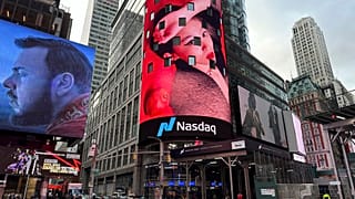 Pedestrians walk past the Nasdaq building in New York on Tuesday, March 26, 2024. 