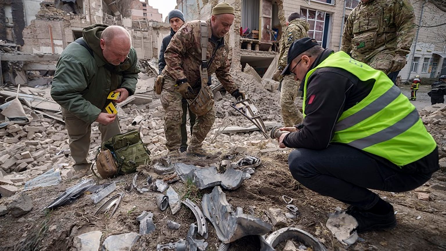 Ukrán katonai szakértők egy rakéta maradványait gyűjtik egy lerombolt épület mellett a Pecserszkij kerületben, egy orosz légitámadás után az ukrajnai Kijevben 2024. március 25