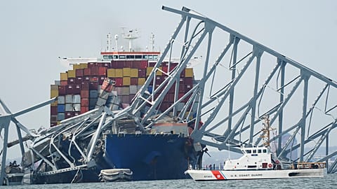 Die Küstenwache fährt an einem Frachter vorbei, das unter einem Teil der Francis-Scott-Key-Brücke festsitzt, nachdem das Schiff am Dienstag, 26. März 2024.