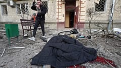 Mann bringt Hund in Sicherheit - in Charkiw in der Ukraine nach russischen Luftangriffen am 27. März 2024