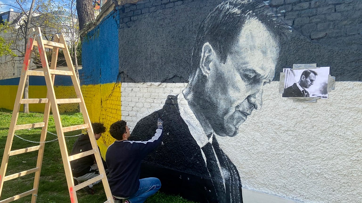 Austrian graffiti duo Joel Gamnou paint a picture of Alexei Navalny on a wall in Vienna, Austria, Wednesday, 27 March 2024.