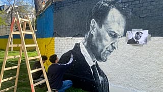 Austrian graffiti duo Joel Gamnou paint a picture of Alexei Navalny on a wall in Vienna, Austria, Wednesday, 27 March 2024.
