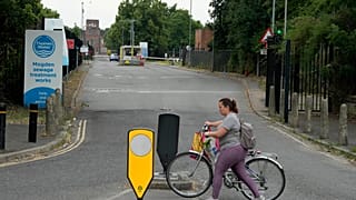 A woman passes the entrance of the Thames Water plant in Twickenham, London, Wednesday, June 28, 2023.(AP Photo/Frank Augstein)