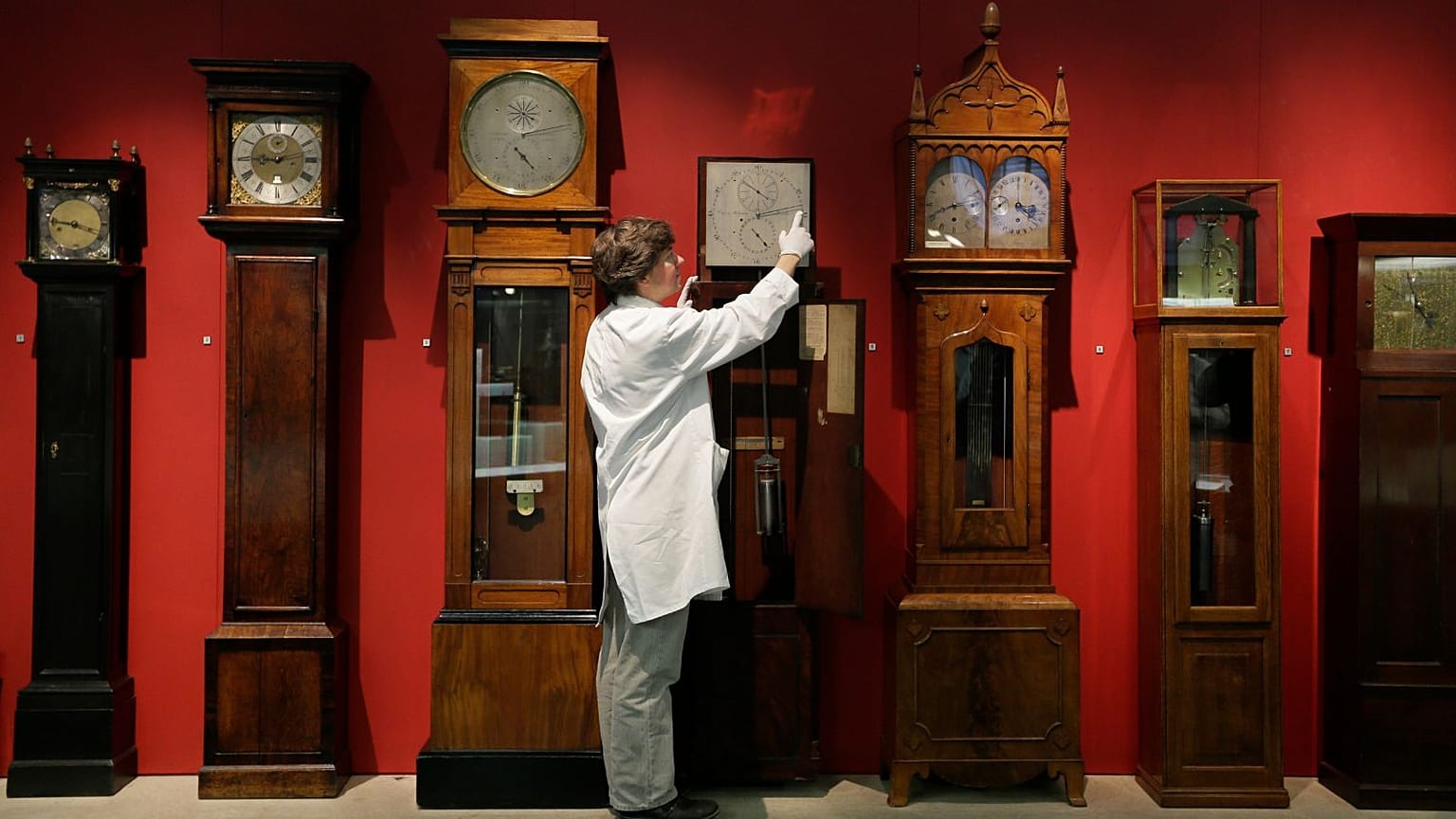 A conservator adjusts clocks in the Science Museum's Measuring Time gallery in London, October 2012.