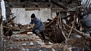 Imagen de una ciudadana ucraniana, delante de su casa, que ha sido destruida por un ataque de Rusia con drones, un barrio residencial de Zaporiyia.