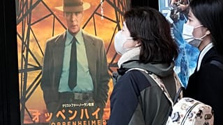 İnsanlar Tokyo'da "Oppenheimer" filmini tanıtan bir posterin yanından geçiyor, 29 Mart 2024 