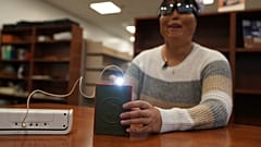 Minh Ha, Manager für Hilfsmittel an der Perkins School for the Blind, probiert zum ersten Mal ein LightSound-Gerät aus.