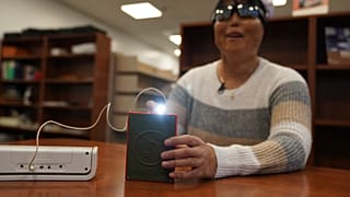 Minh Ha, responsable de tecnología de apoyo de la Escuela para Ciegos Perkins, prueba por primera vez un dispositivo LightSound.