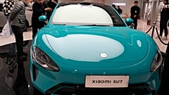 Visitors to the Xiaomi Automobile flagship store look at the Xiaomi SU7 electric car on display in Beijing, Tuesday, March 26, 2024.