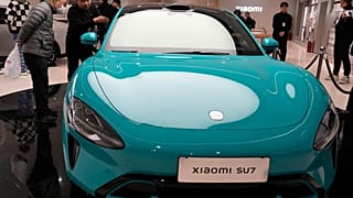 Visitors to the Xiaomi Automobile flagship store look at the Xiaomi SU7 electric car on display in Beijing, Tuesday, March 26, 2024.