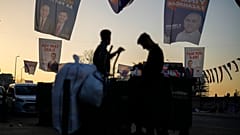 People walk under campaign banners of candidates for Istanbul of Justice and Development Party, or AKP, and Republican People's Party, or CHP, in Istanbul
