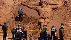 Einer Sandskulptur, die Jesus Christus am Kreuz darstellt, in Los Arenales de Cochiraya, am Stadtrand von Oruro. 30. März 2024