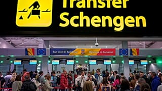 Passengers arriving at Henri Coanda international airport pass under a Schengen information board in Otopeni, near Bucharest, Romania, on 31 March 2024.