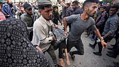 فلسطينيون يحملون جريحاً بعد غارة جوية إسرائيلية استهدفت خيماً بالقرب من مستشفى الأقصى في دير البلح