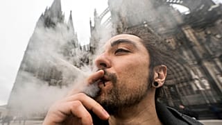 Un hombre fuma cánnabis frente a la Catedral de Colonia, Alemania, en un acto de consumo público tras el inicio de una nueva ley el lunes 1 de abril de 2024.