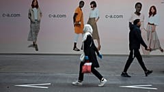 In this Monday, May 11, 2020 file photo, a woman and man walk past each other on a main shopping street in Antwerp, Belgium. 