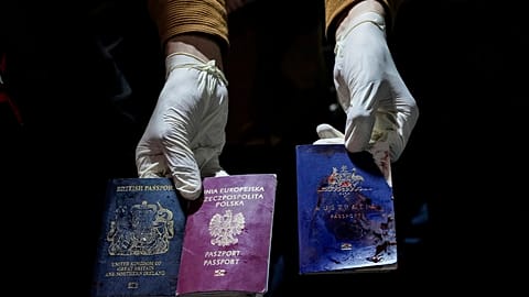 A man displays blood-stained British, Polish, and Australian passports after an Israeli airstrike, in Deir al-Balah, Gaza Strip, Monday, April 1, 2024