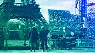 People watch workers building the stands for the upcoming summer Olympic Games on the Champ-de-Mars just beside the Eiffel Tower, in Paris, April 2024