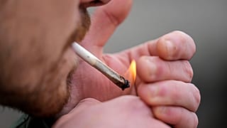 Мужчина курит каннабис перед Кафедральным собором в Кельне, Германия, во время публичного мероприятия, посвященного началу действия нового закона, в понедельник, 1 апреля.