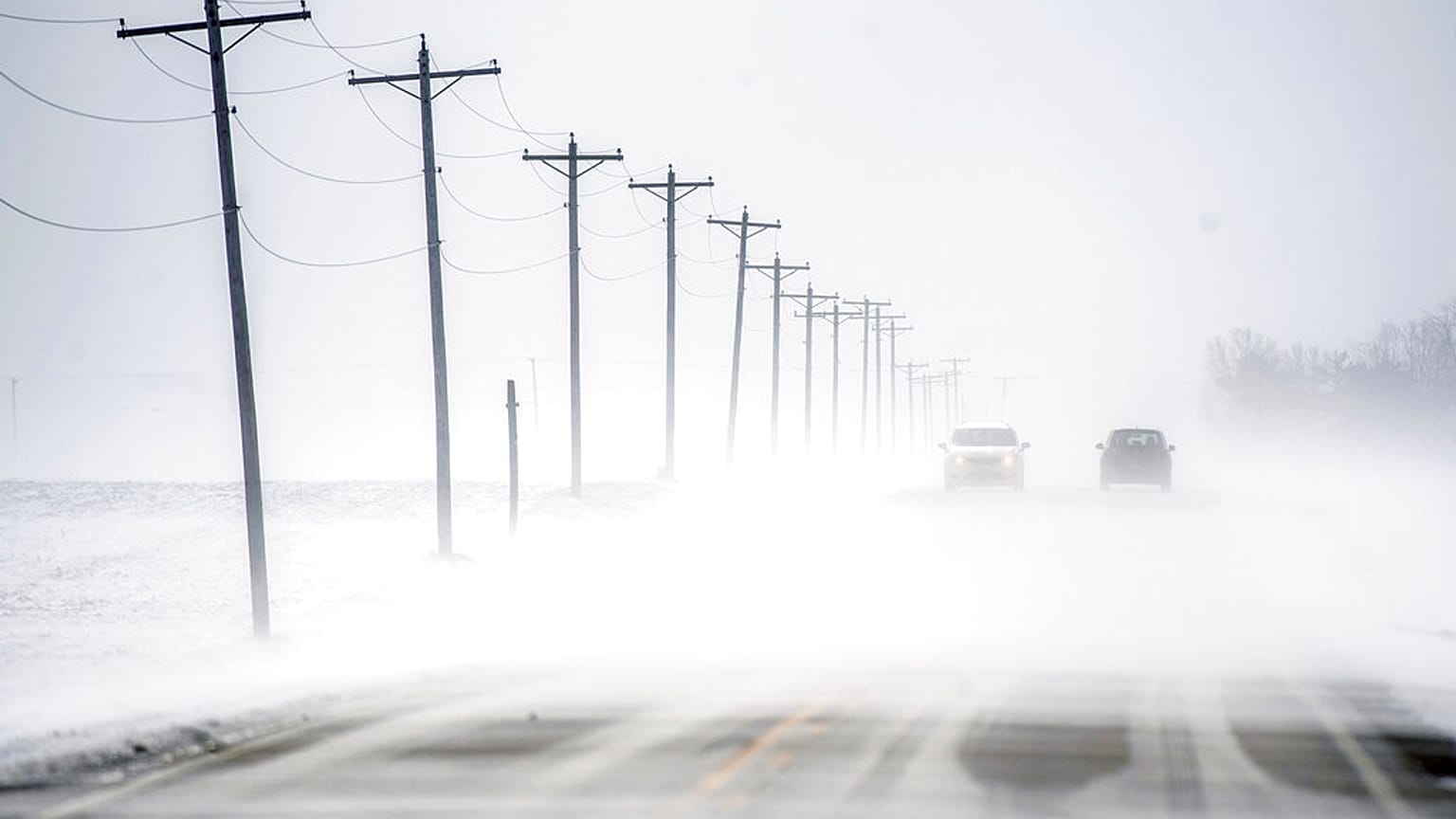 Wind-driven snow blowing east to west rolls over Dee-Mac Road between Washington and Eureka, Ill., on Wednesday, Jan. 5, 2022.