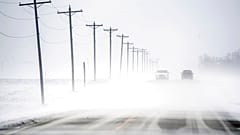 Wind-driven snow blowing east to west rolls over Dee-Mac Road between Washington and Eureka, Ill., on Wednesday, Jan. 5, 2022.