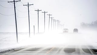 Wind-driven snow blowing east to west rolls over Dee-Mac Road between Washington and Eureka, Ill., on Wednesday, Jan. 5, 2022.