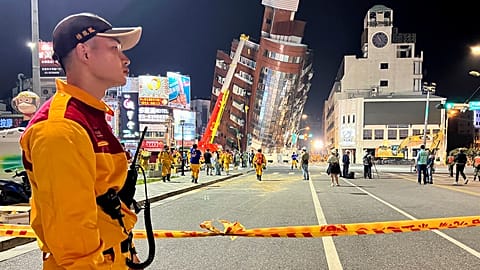 A rescue worker stands near the cordoned off site of a leaning building in the aftermath of an earthquake in Hualien, eastern Taiwan on Wednesday, April 3, 2024.