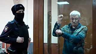 The co-chair of the Nobel Peace Prize winning Memorial Human Rights Centre Oleg Orlov gestures standing in a glass cage after he was taken into custody in the courtroom,Feb 23