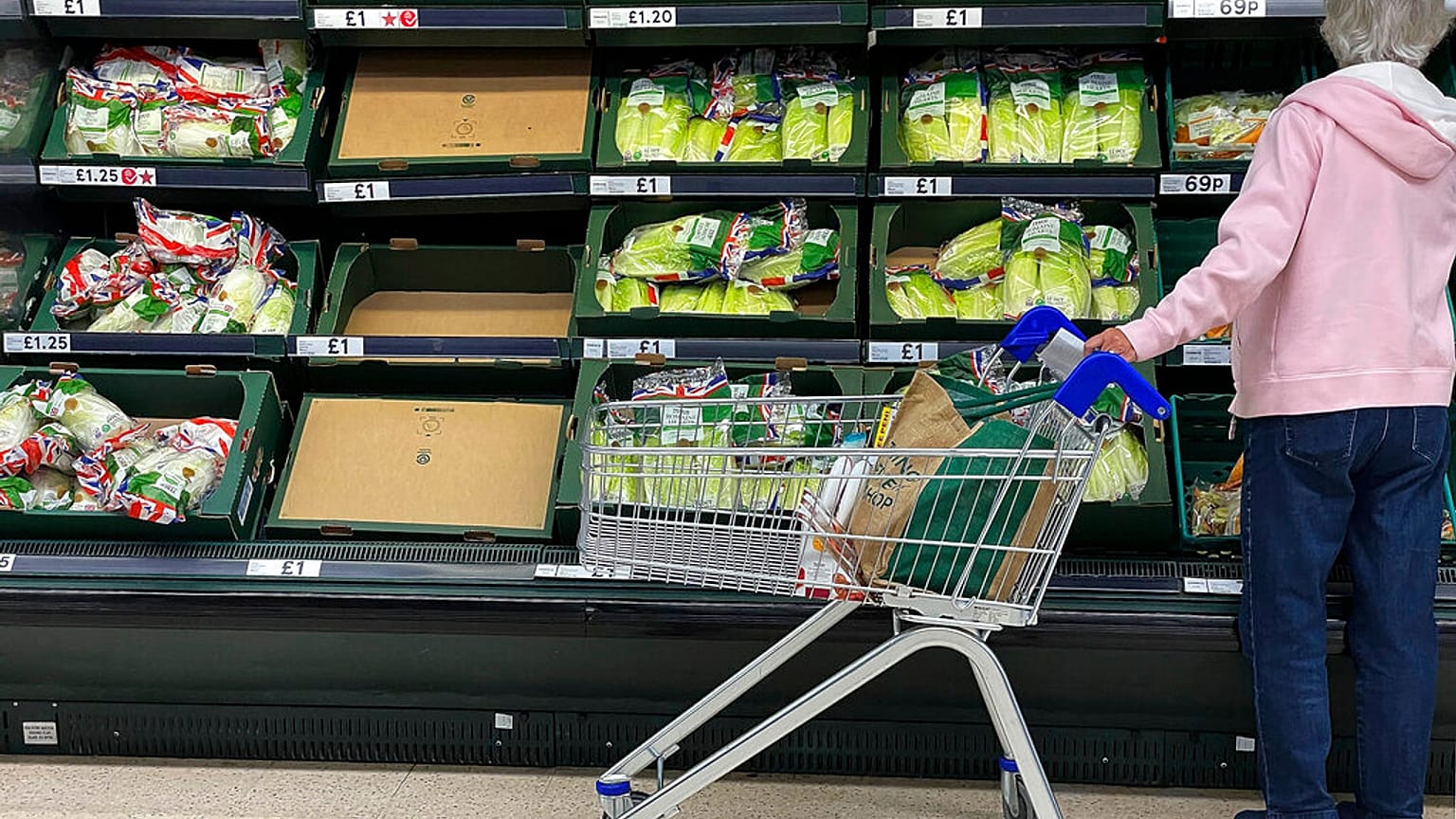 A shopper faces partly empty shelves in a supermarket in London, Thursday, Sept. 30, 2021. 