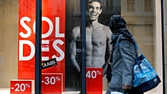 A woman looks at a store advertising for winter sales in Lyon, central France, Thursday, Jan. 7, 2016. 