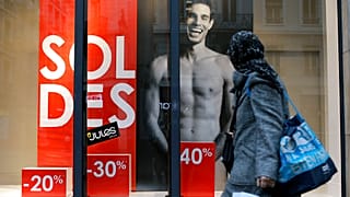 A woman looks at a store advertising for winter sales in Lyon, central France, Thursday, Jan. 7, 2016. 