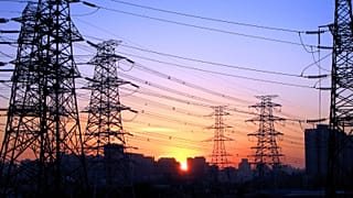 The sun sets between power lines in Beijing, China.