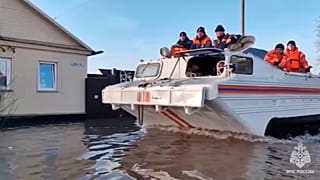 Εmergency workers aboard an amphibious vehicle look to evacuate local residents after a part of a dam burst causing flooding, in Orsk, Russia