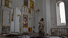 A Ukrainian serviceman prays kneeling in a church damaged in the Russian air raid in the town of Orikhiv, Zaporizhzhia region, Ukraine, Friday, Apr. 5, 2024.