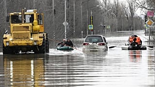 People use rubber boats in a flooded street after part of a dam burst, in Orsk, Russia.