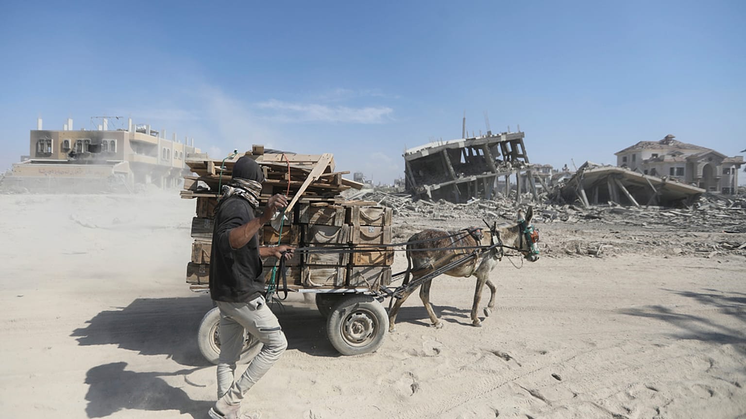 Palestinians walk through the destruction left by the Israeli air and ground offensive after they withdrew from Khan Younis, southern Gaza Strip, Sunday, April 7, 2024.