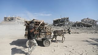 Palestinians walk through the destruction left by the Israeli air and ground offensive after they withdrew from Khan Younis, southern Gaza Strip, Sunday, April 7, 2024.