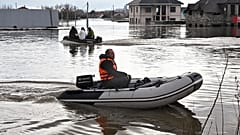 People use rubber boats in the flooded street after part of a dam burst, in Orsk, Russia. State media say Russia's government has declared the situation in flood-hit areas in 